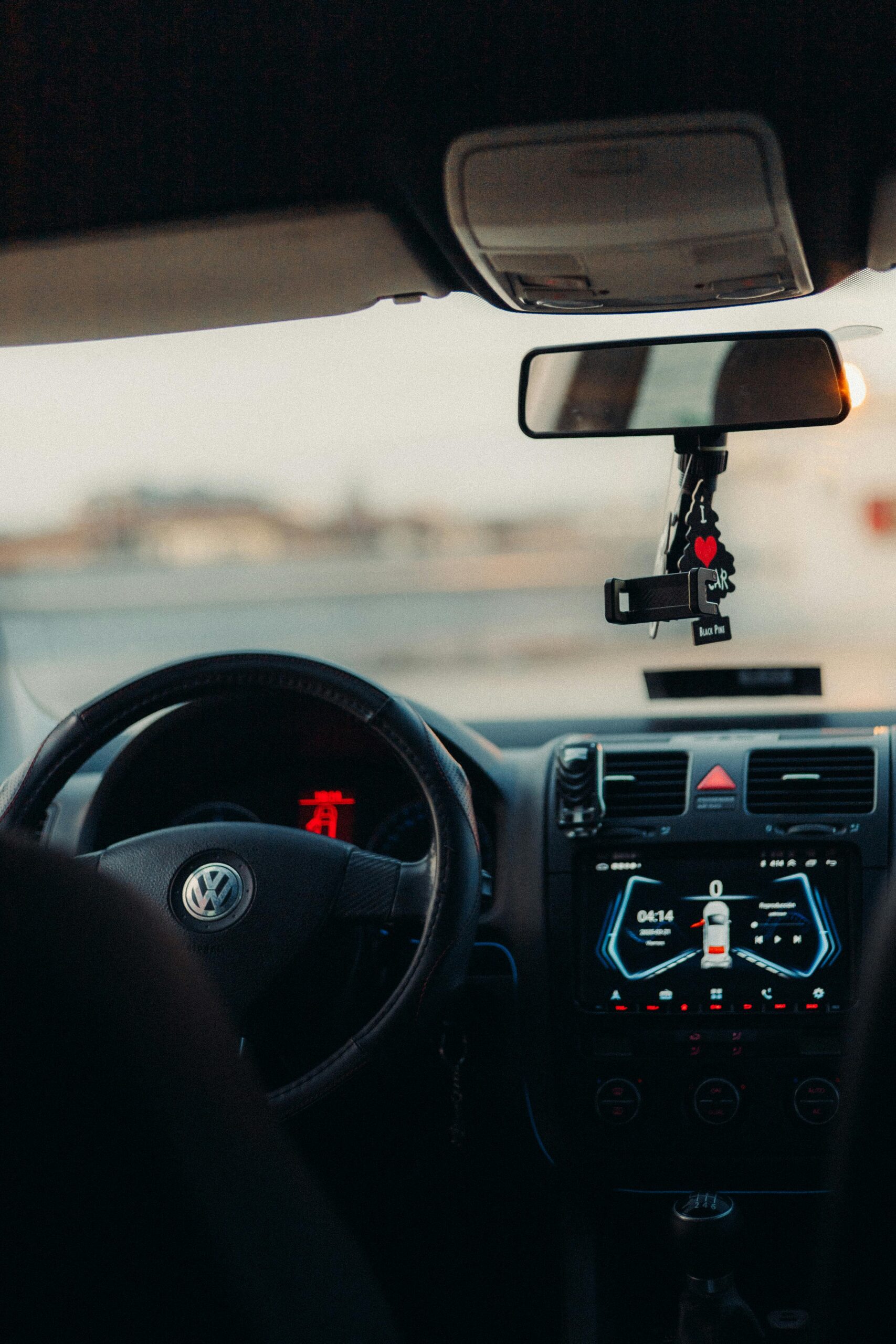 View of a car interior focusing on the dashboard and rearview mirror.
